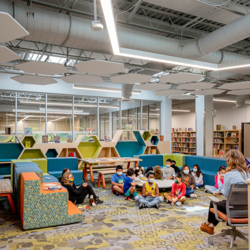 Kids listening to a teacher read to them.