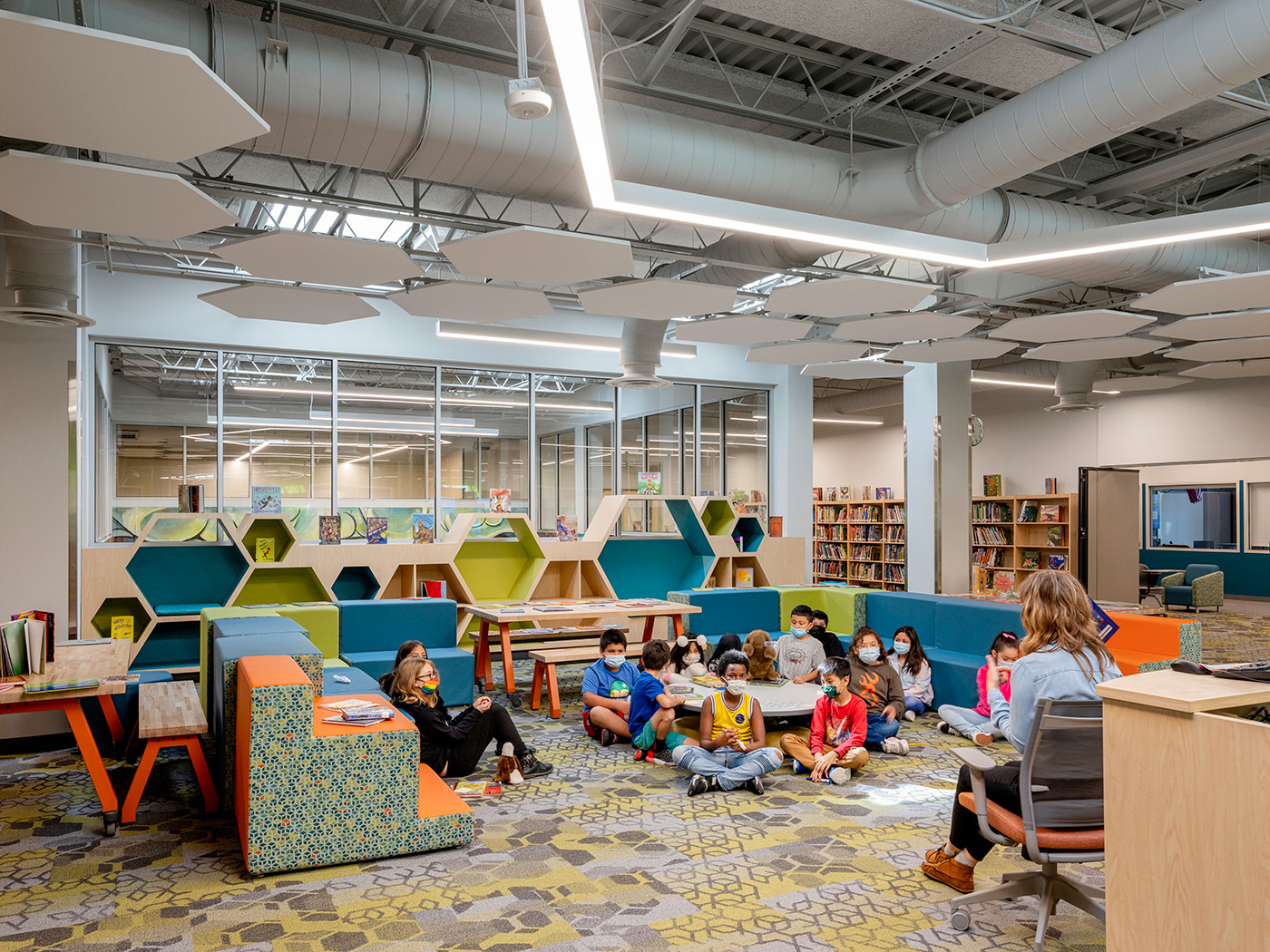 Kids listening to a teacher read to them.