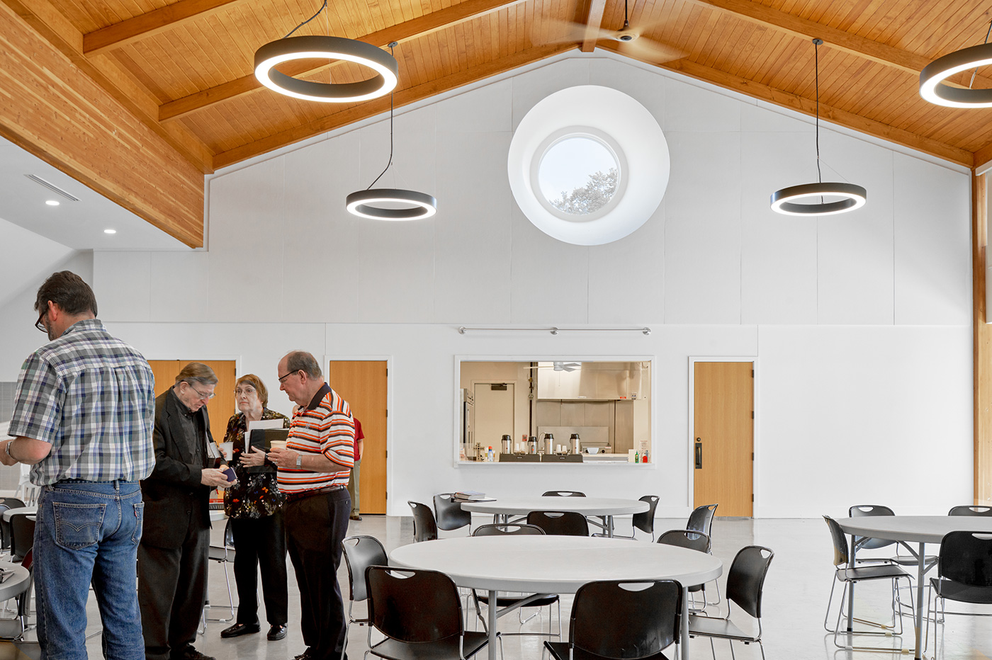 People conversing in dining area of a church.