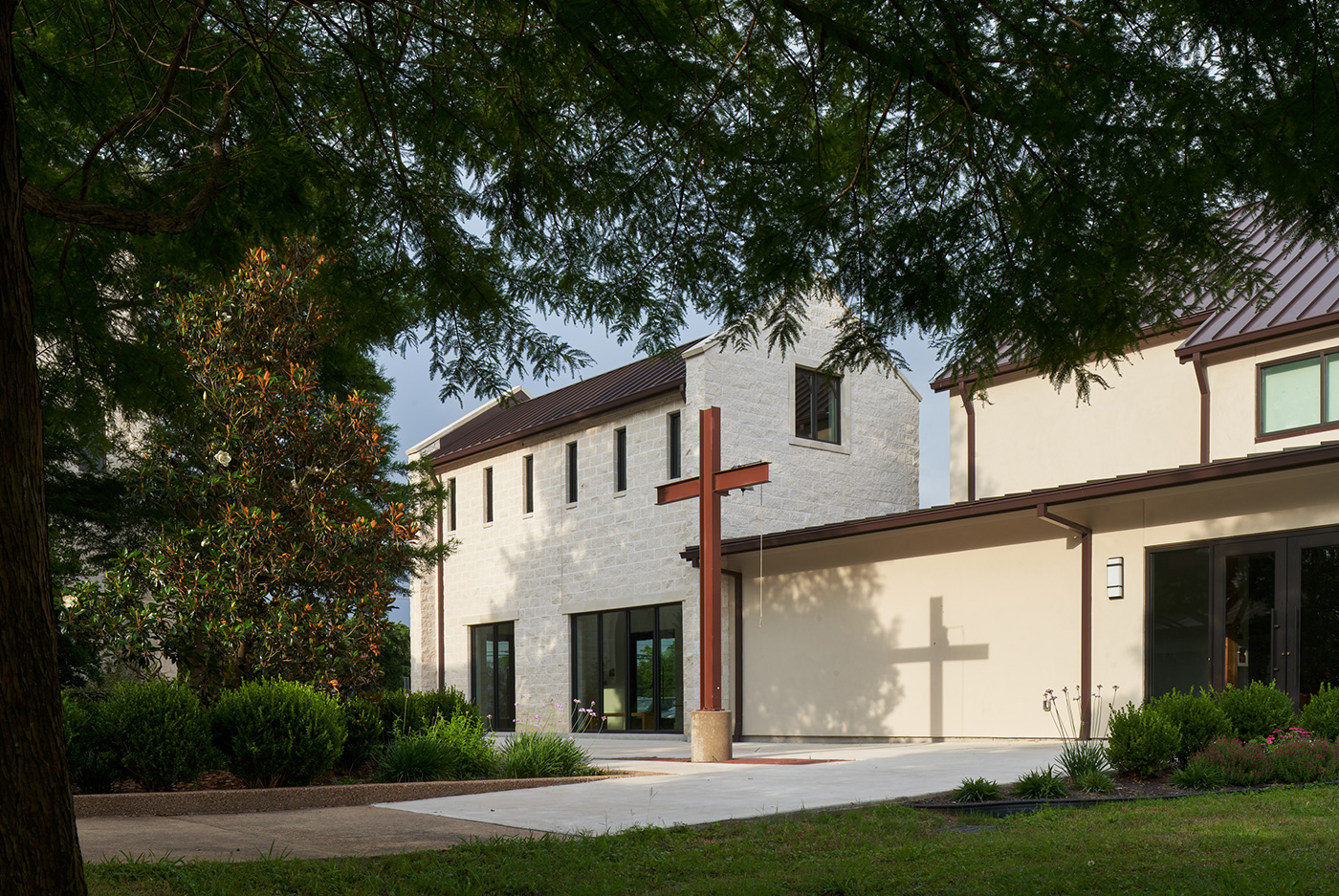 Cross Infront of a modest modern church.