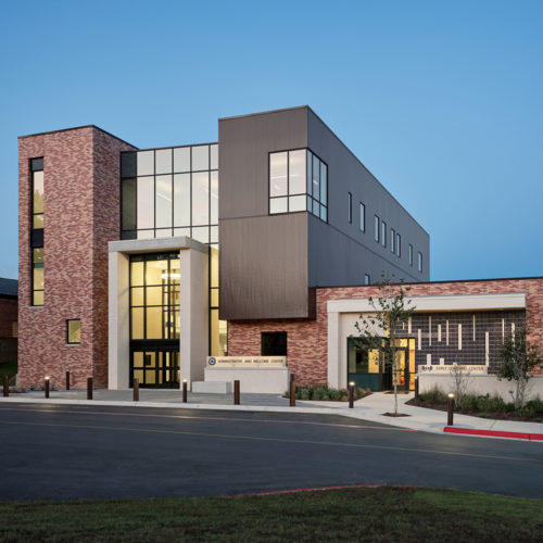 The large front facade of a modern building with a sign that reads "ADMINISTRSTIVE AND WELCOME CENTER".