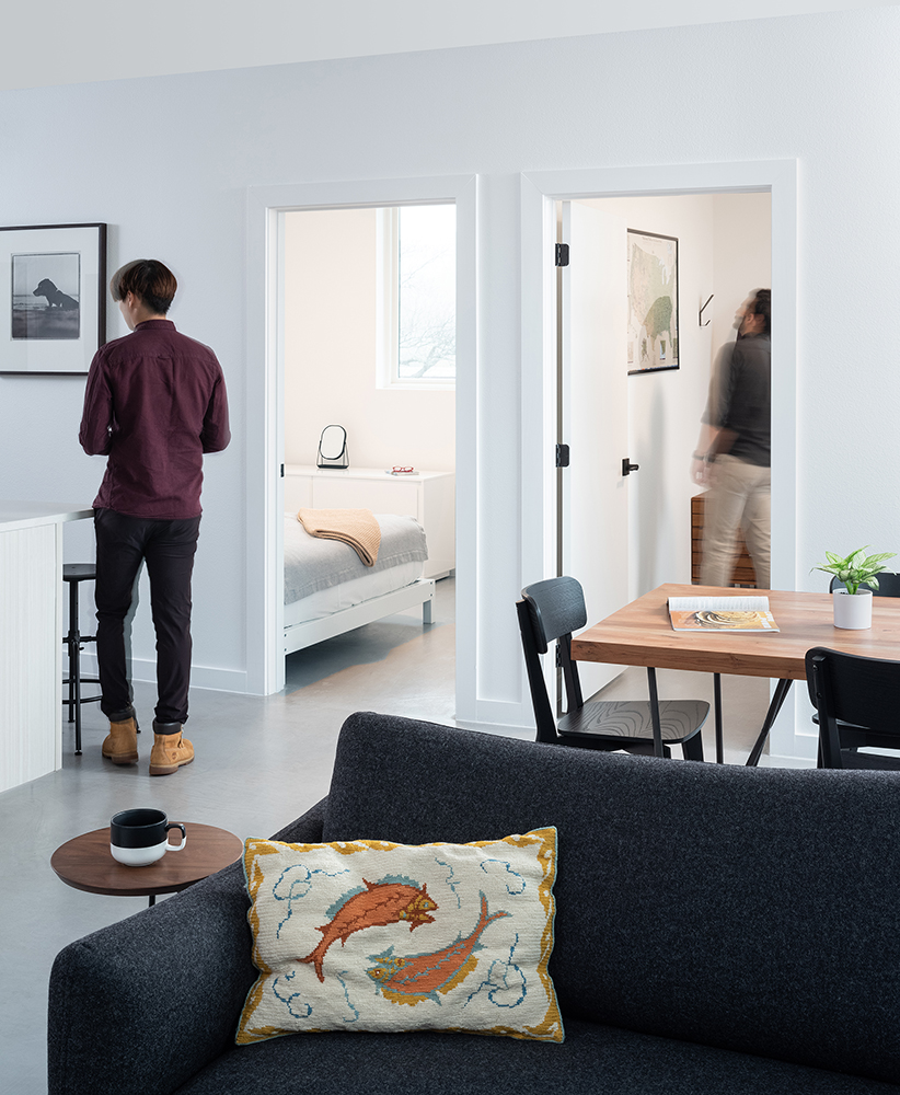 white living room with doors to two bedrooms open in background.