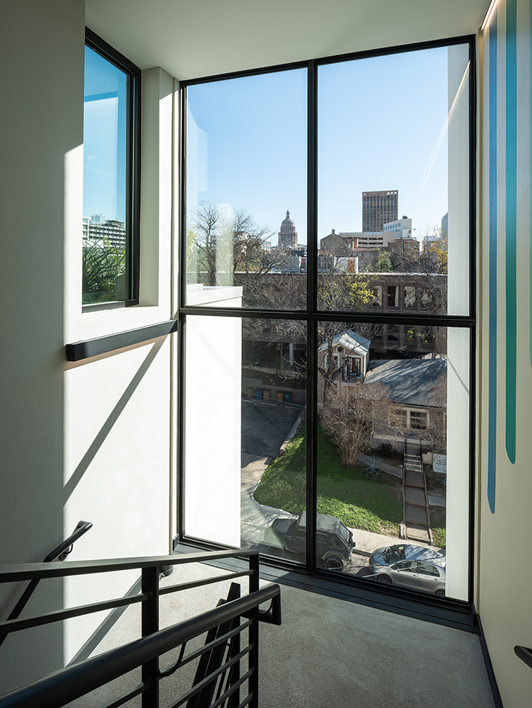 Stairwell with large floor to ceiling windows facing the street.