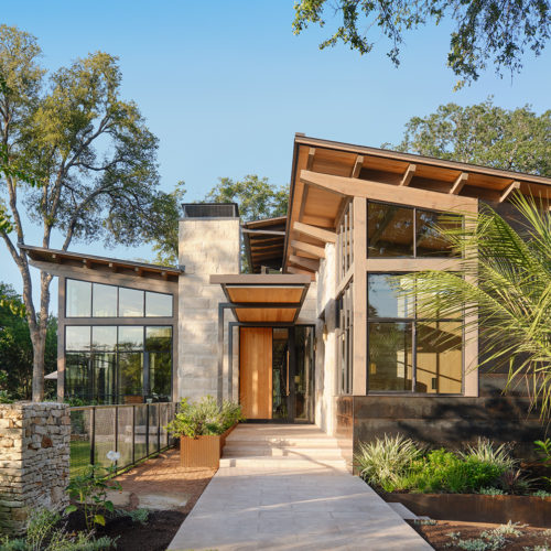 A head-on view of a house and its surrounding landscaping.