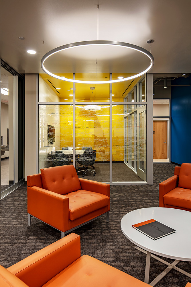 Large chairs around table infront of glass conference room.