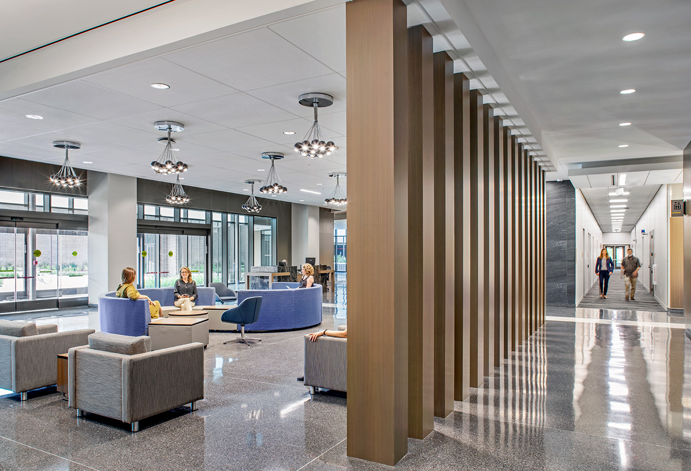 People walking through and sitting in an offices lobby.