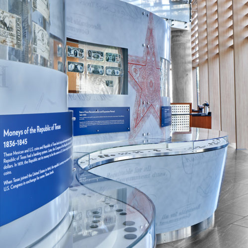 A close-up photo of display cases with old coins attached to a wall.