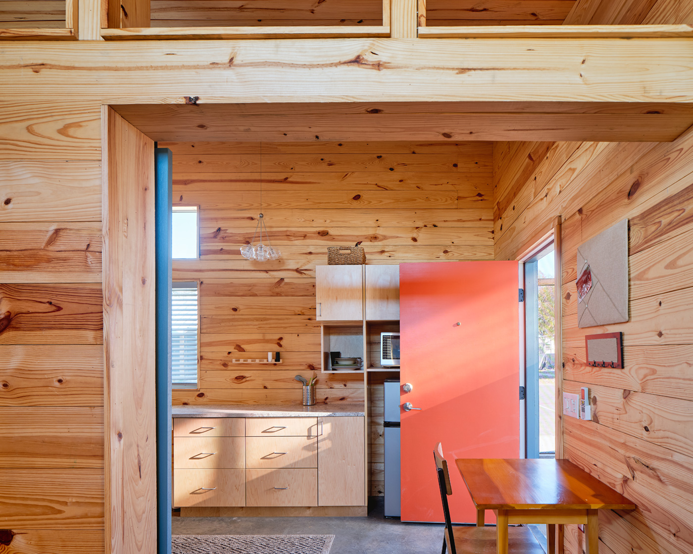 The front door and wooden kitchen of a tiny home.