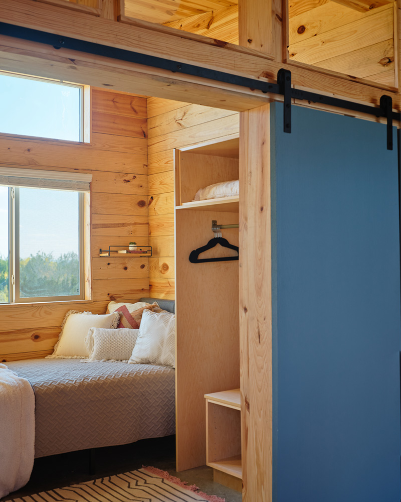 A small wooden bedroom and closet.