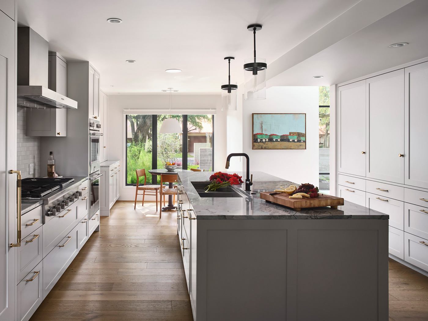 Kitchen and small dining room with windows to a backyard.