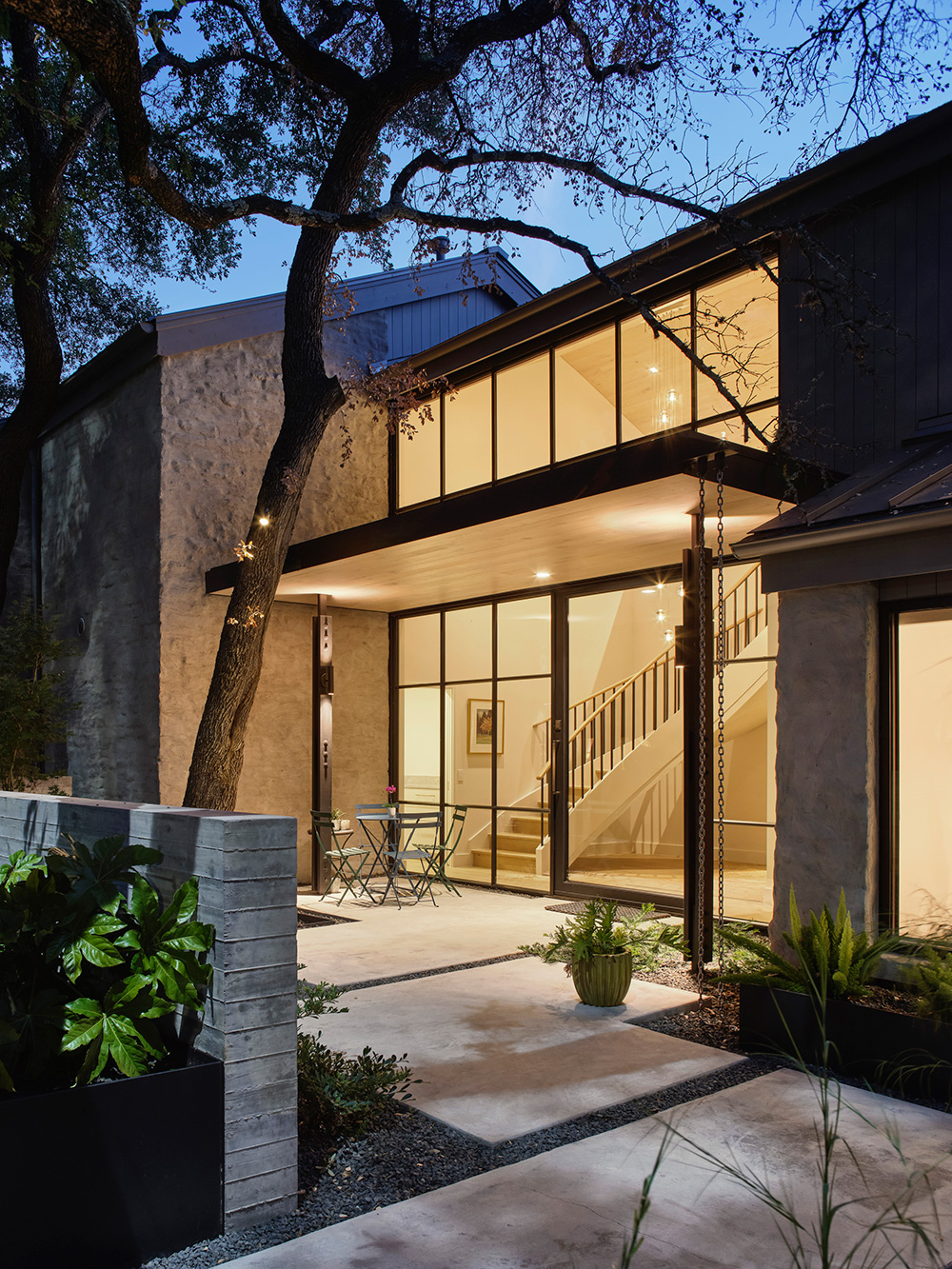 Concrete front patio and entrance of a home at dusk.