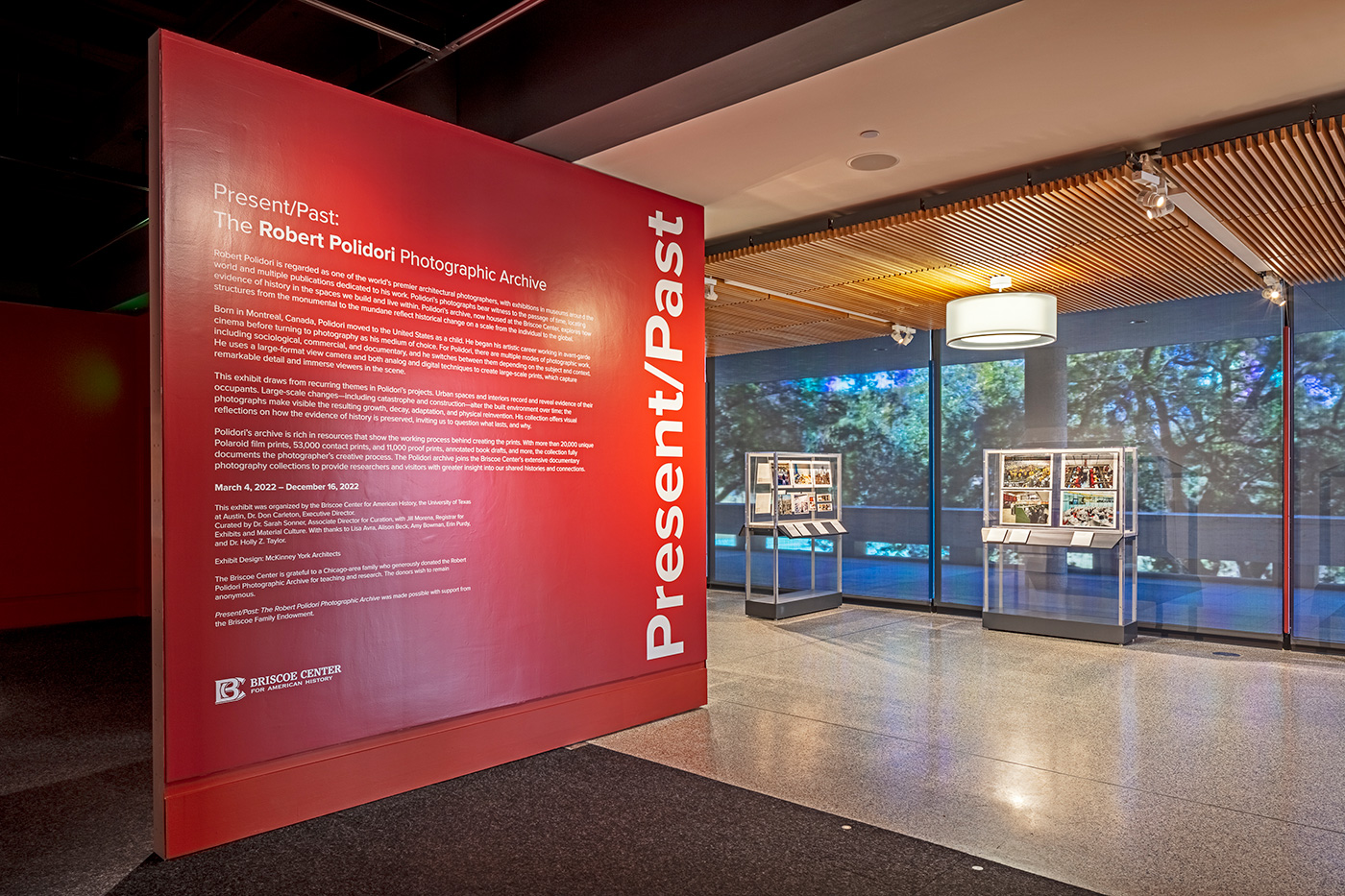 Two display cases outside on the entrance to an art exhibit in a hallway.