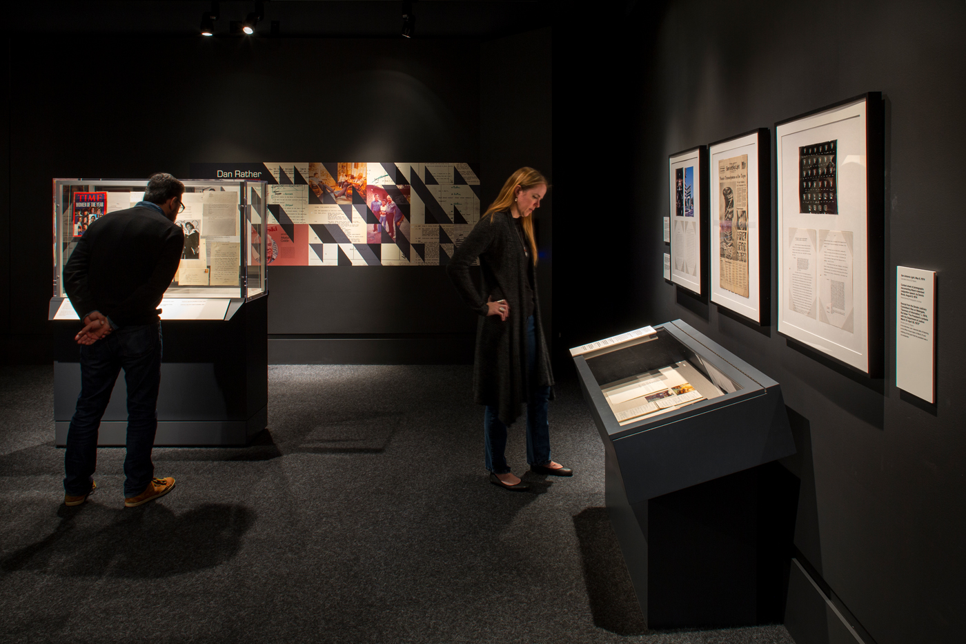 Women leaning over reading information in display case.