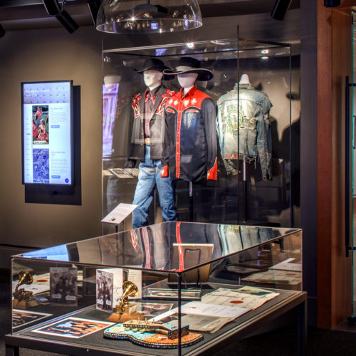Outfits and objects in glass display cases at a museum.