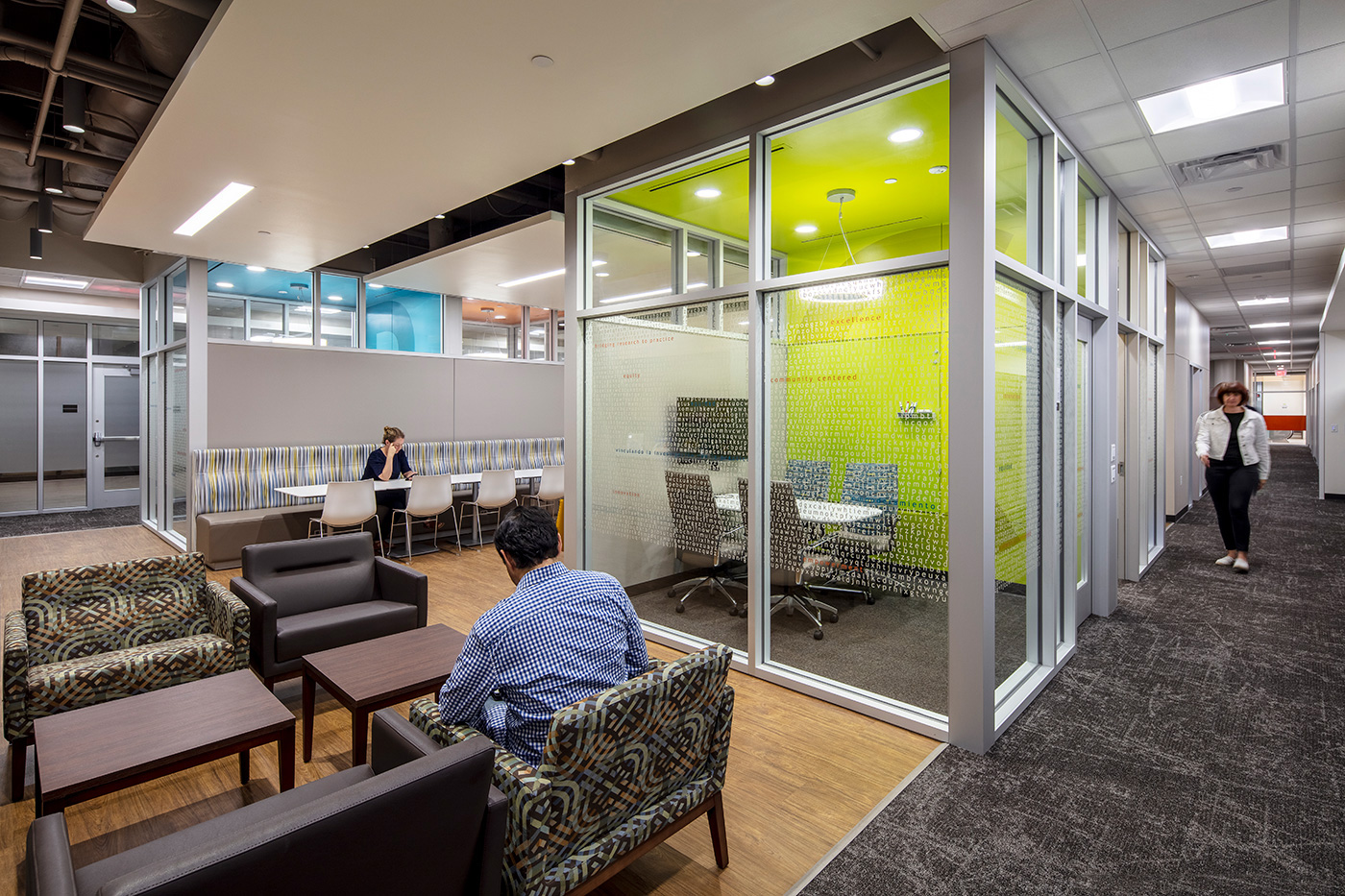 People walking through and sitting in large open seating and meeting space.