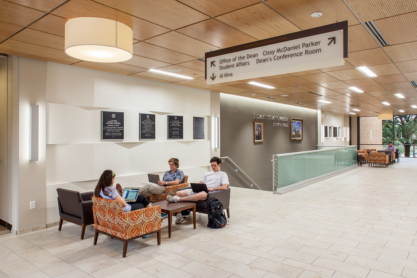 Students working at small seating area in front of stairs.