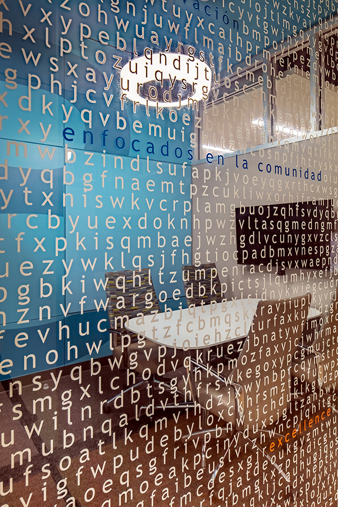 Up-close photo of letters spanning across glass wall of conference room.