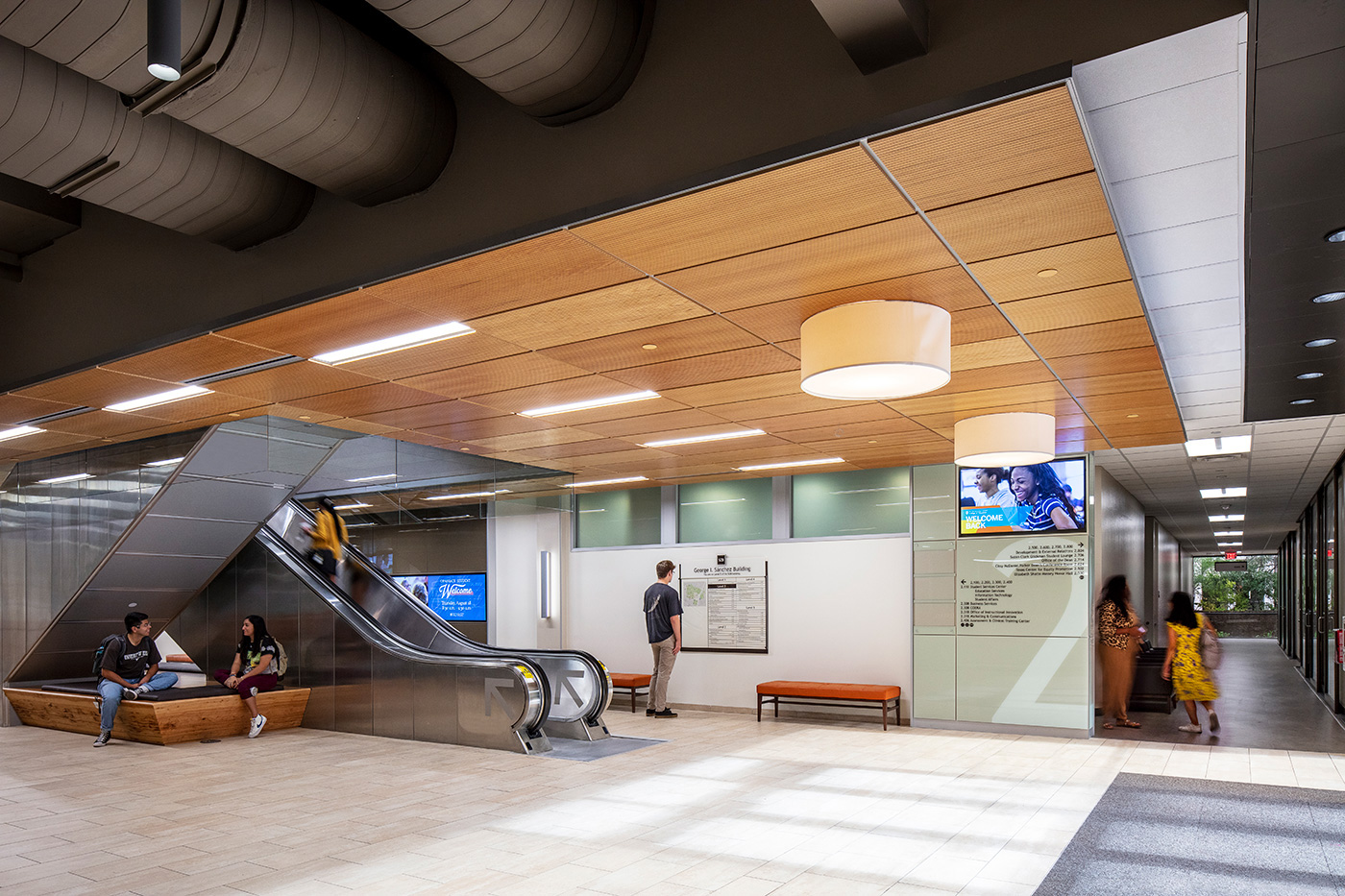 People walking through buildings central escalator lobby space.