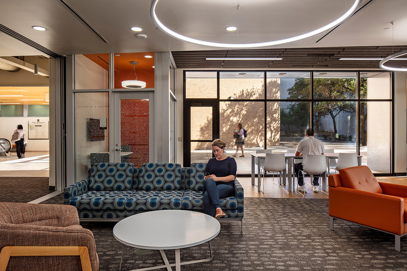 People sitting in modern office's colorful seating area.