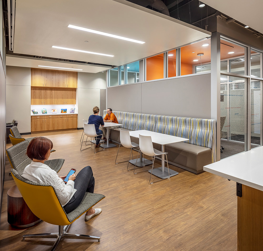 People sitting in office's eating and working space.