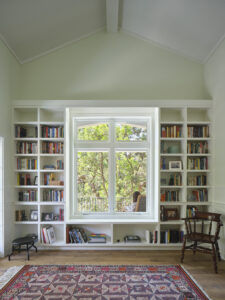 Bookshelf's surrounding the central window of a white room.