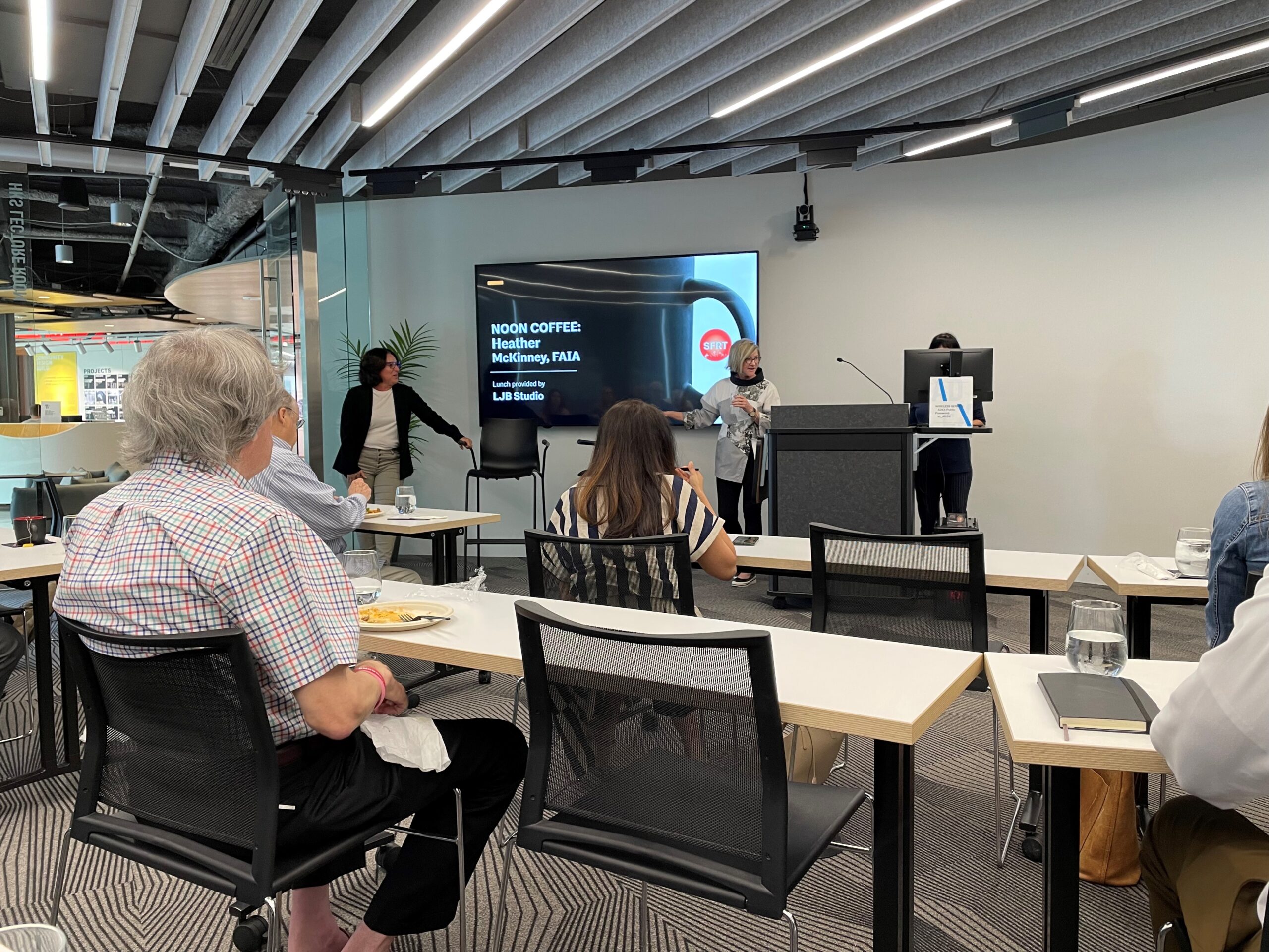 Heather presenting at AIA speaking engagement with audience at tables in foreground