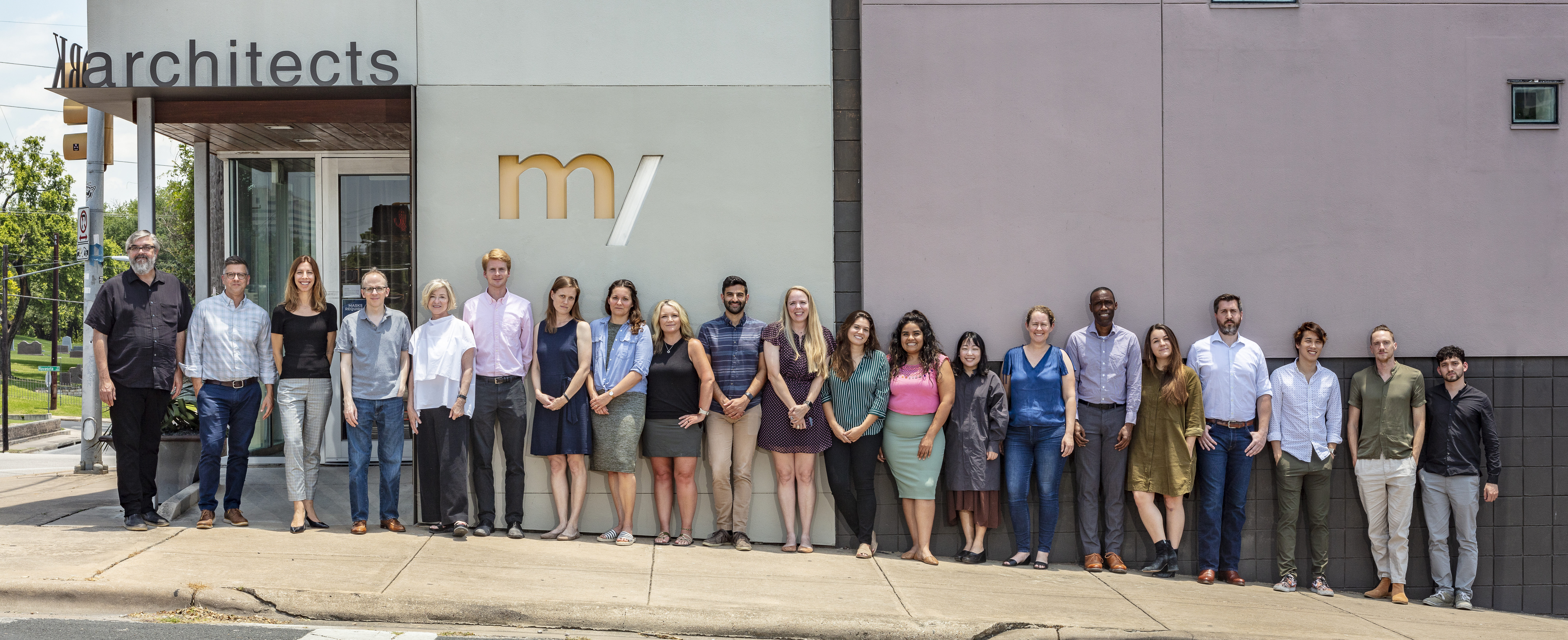 Firm staff standing along sidewalk shoulder to shoulder in front of McKinney York Architects office building