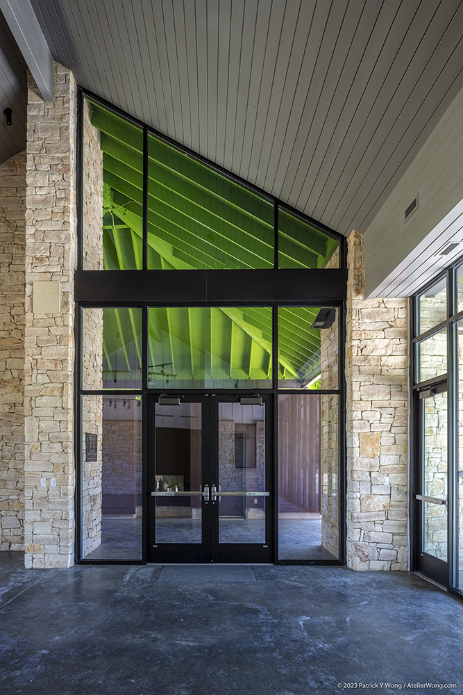 Glass doors inside an atrium with stone walls.