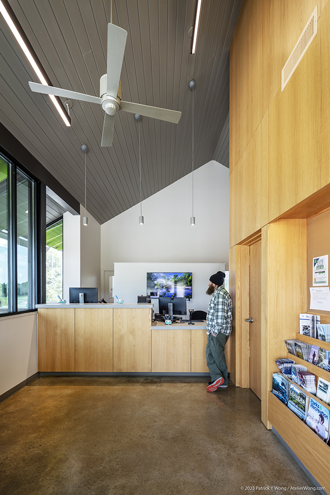 A man standing in front of a wooden reception desk.