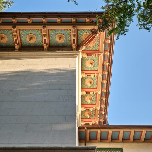 Ornamental carved eave details on a historic stone building.