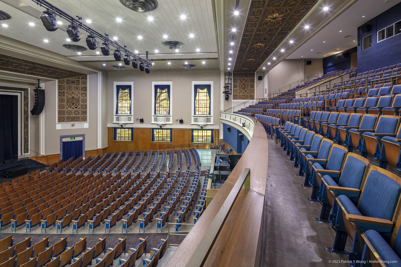 View along the edge of a balcony in an auditorium.